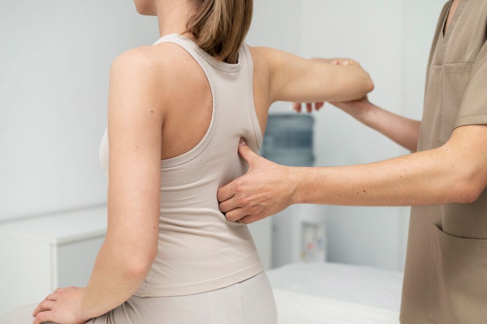 Chiropractor assisting a patient with back pain relief through physical therapy, emphasizing the importance of seeking treatment for persistent back pain.