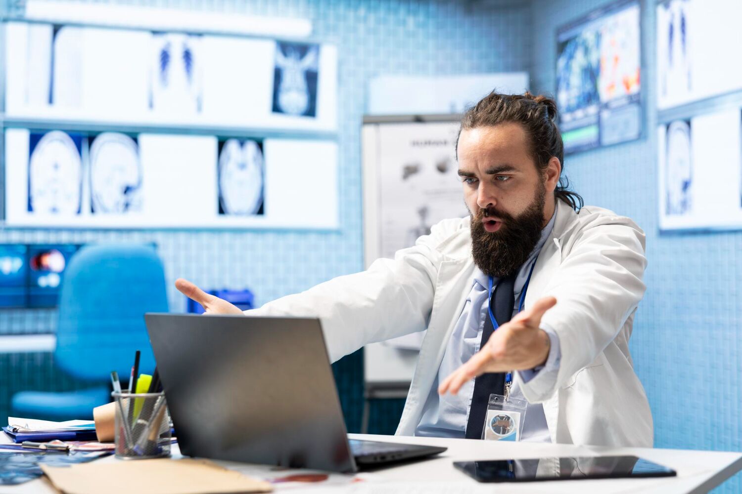 Doctor explaining medical concepts on a laptop during a virtual consultation, guiding how to find BlueCross BlueShield doctors for pain management services.